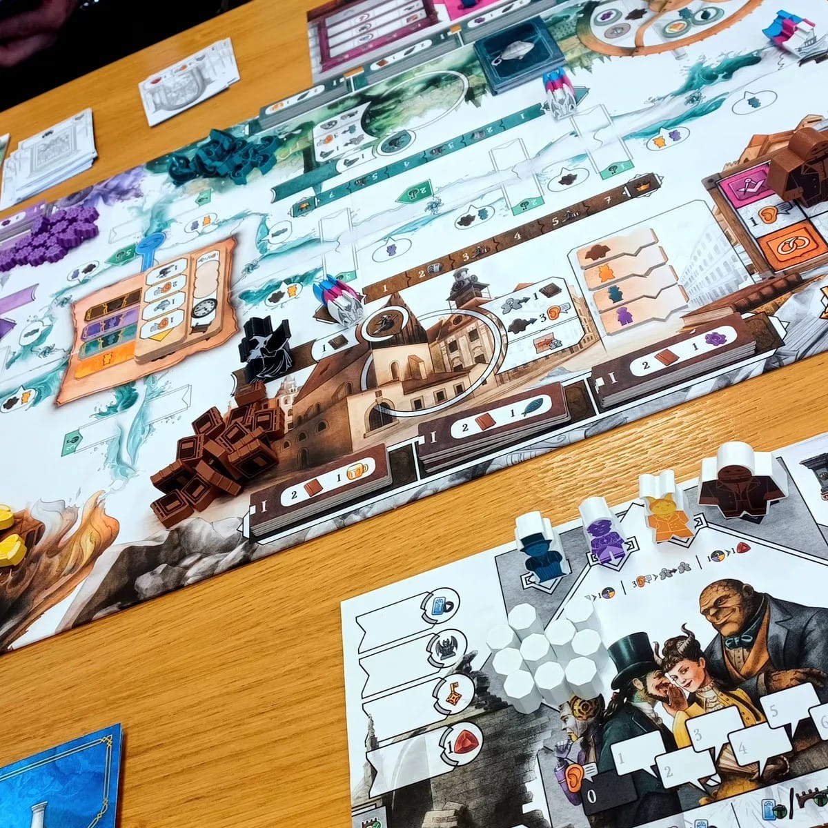 Aufgebautes Spielbrett von „Prag im Verborgenen“ mit Spielertableaus und Holzkomponenten